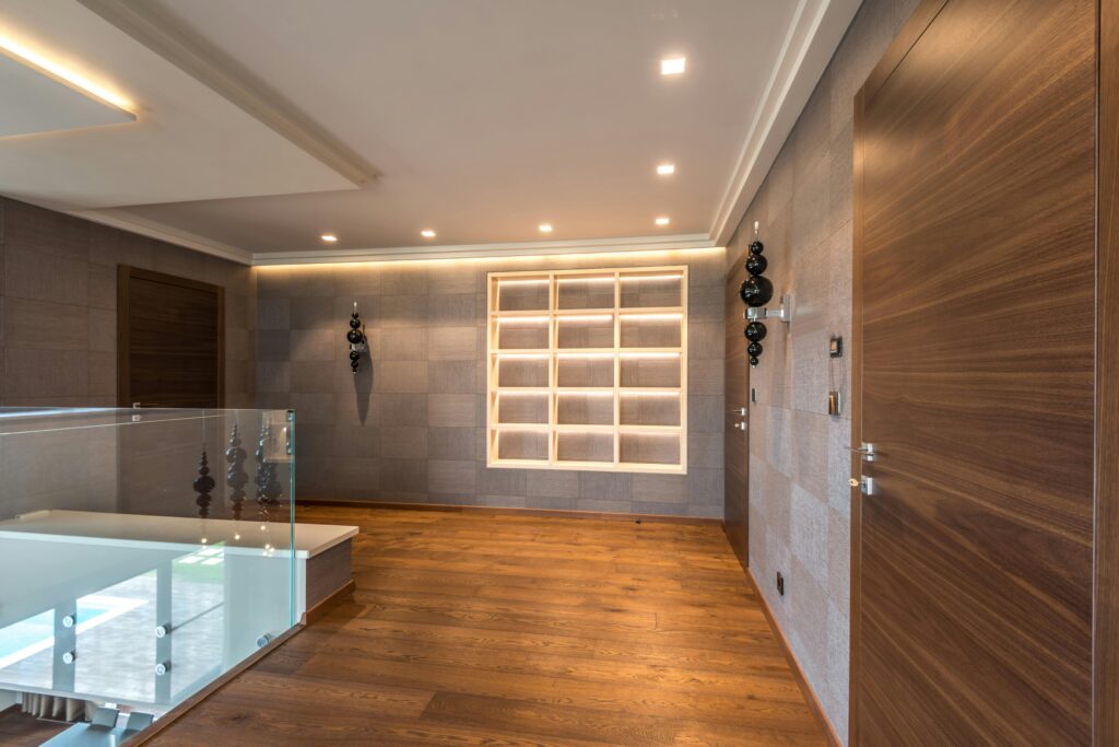 Spacious modern interior featuring wooden doors, flooring, and minimalistic design elements.